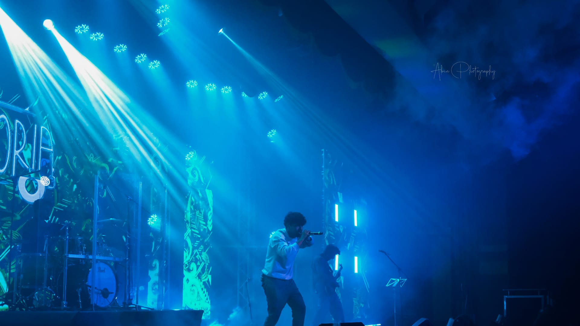 A singer on a smoke-filled stage lit entirely in blue